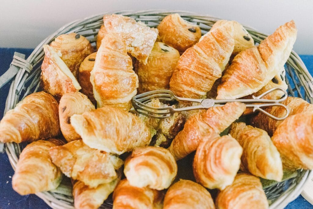 Close-up of a wicker basket filled with golden croissants and pastries.